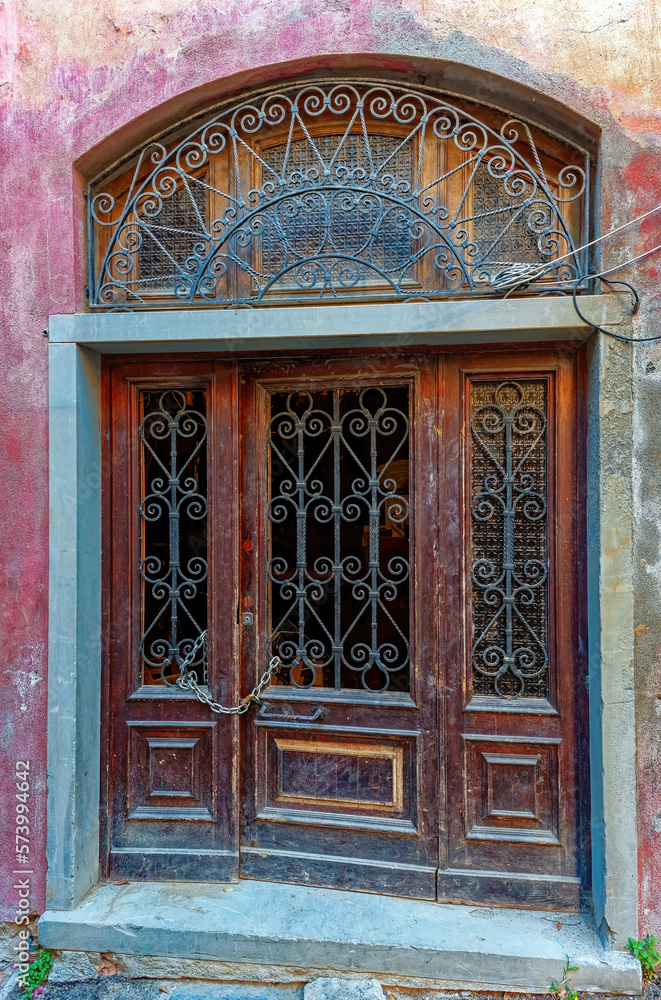 Antique wooden door with openwork metal grille Florence, Tuscany