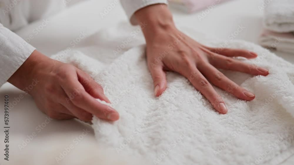 A woman's hand glides over a white towel, a gentle movement of her hand over fresh clean linen, a girl leads her hand through clean things from a dry-cleaner's laundry
A woman's hand glides over a white towel, a gentle movement of her hand over fresh clean linen, a girl leads her hand through clean things from a dry-cleaner's laundry