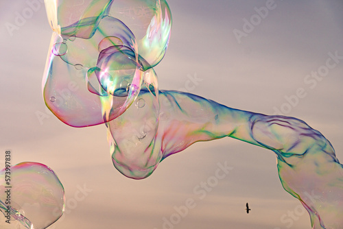 Sunlight refracting through Large colorful bubbles on the ocean coast during sunset.