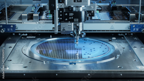 Semiconductor Wafer after Dicing Process. Silicon Dies are Being Extracted by Pick and Place Machine. Computer Chip Manufacturing, Packaging Process. photo