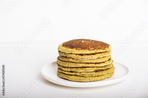 Delicious freshly cooked avocado pancakes stacked on white plate. Copy space for text. Healthy gluten free food.
