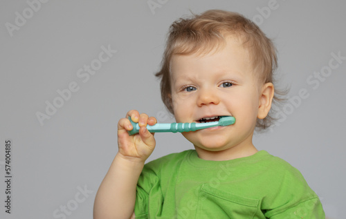 Cute baby 2 years old brushes his teeth with a toothbrush. The concept of oral hygiene and healthy teeth from infancy.