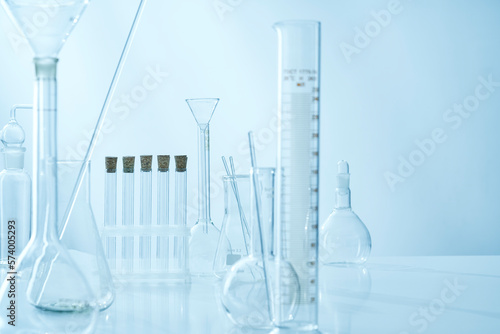 Glass test tubes, various dishes of a chemical laboratory on a light background.