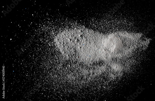 Washing powder, pile detergent isolated on black background and texture