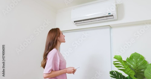 woman turn on air conditioner photo