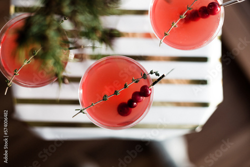 Bright red holiday cranberry cocktails complete with decorative flags and topped with a thyme garnish