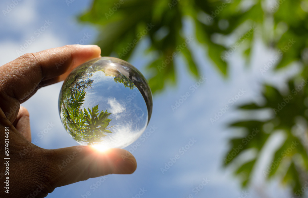 A hand holding crystal ball for eco friendly or sustainable resources concept. Saving environment from global warming.