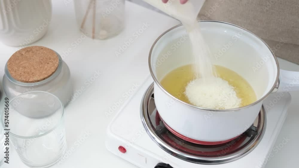Creative occupation of candle making, pouring and melting soy wax in the pot and stirring it Creative occupation of candle making, pouring and melting soy wax in the pot and stirring it