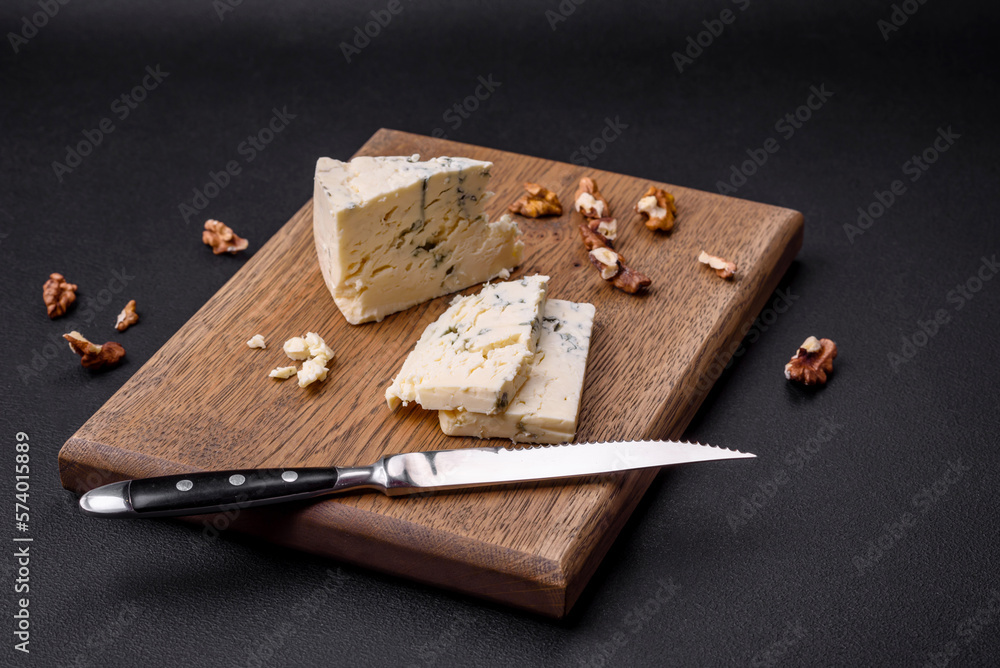 Delicious fresh cheese with blue mold dorblu on a wooden cutting board Delicious fresh cheese with blue mold dorblu on a wooden cutting board