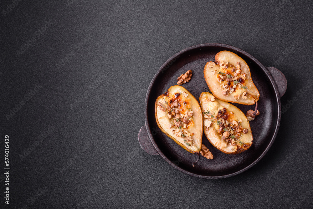 Delicious baked pear with dorblu cheese, walnut and honey on a textured concrete background
