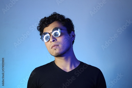 joven latino posando en un fondo azul de neón