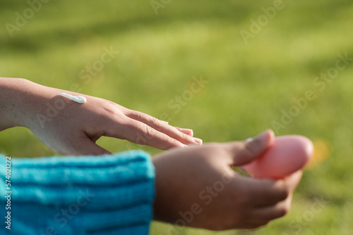Woman with dry skin moisturizing her hands.
