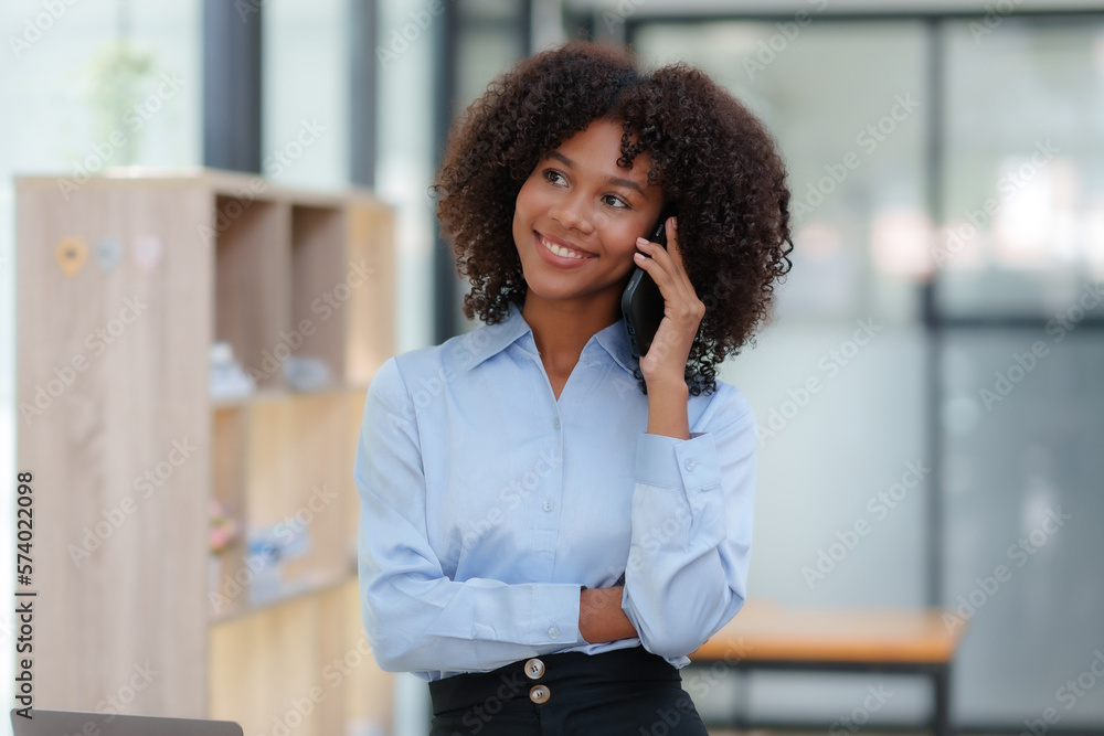 Fototapeta premium Businesswoman talking on the phone happily in the office.