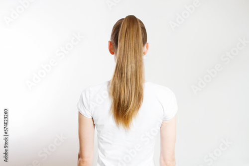 Closeup woman ponytail back view isolated on white background. Hair Natural blonde straight long Hairstyle. Easy quick simple making styling. Hair-extensions for beautiful pony tail. Copy space