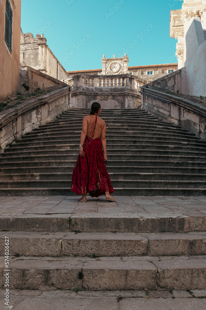 Back of a woman in a dress on Dubrovnik's Jesuit stairs, baroque architecture, Croatia