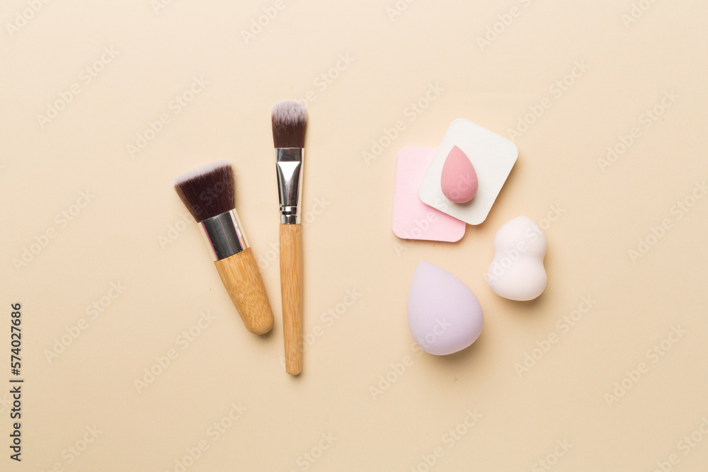 Make up brushes and sponges on color background, top view Make up brushes and sponges on color background, top view