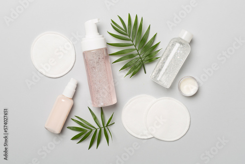 Face care products with eco pads on color background, top view