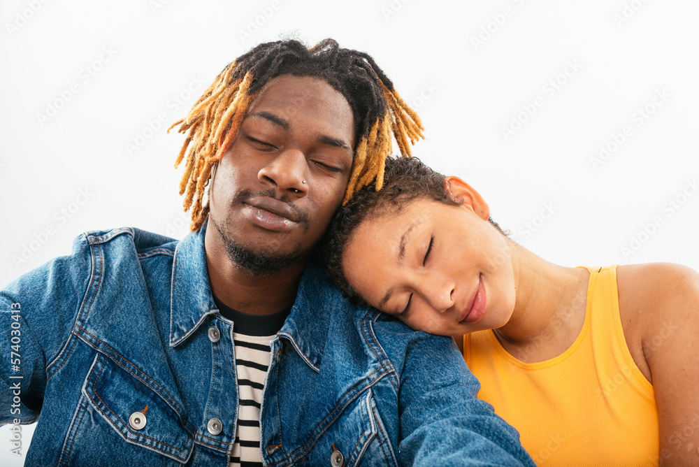 African American couple sitting close to each other in white studio African American couple sitting close to each other in white studio