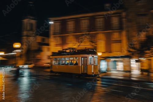 Lisbon tram in motion, panning, driving at night, blurry background