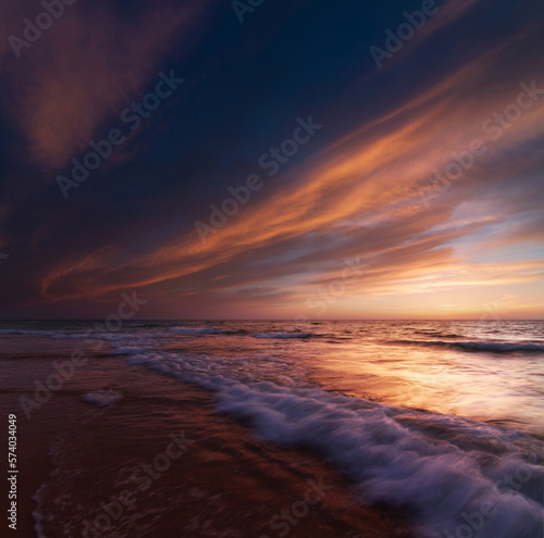 Sunset over the sea shore, sandy beach, colorful sky © Алексей Голубев