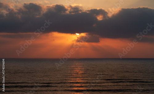 Sunset over the sea. Sunrays and waves