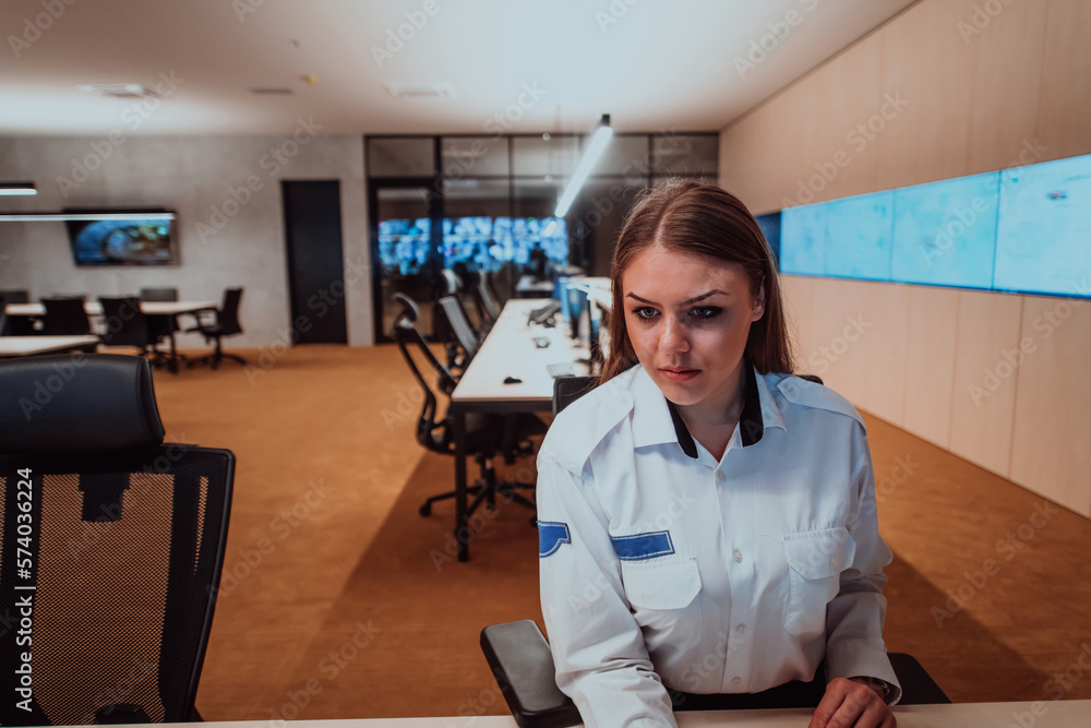 Female security operator working in a data system control room offices ...