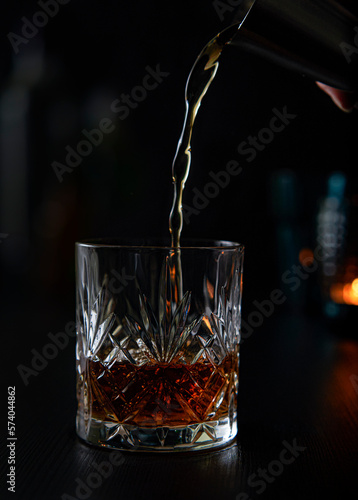 Pouring a glass of whiskey with a cocktail measurer in a fancy bar