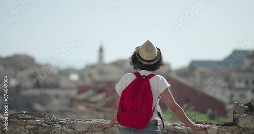 Tourist travel woman in Corfu, Greece. Happy elegant fashion model enjoying vacation in old town visiting famoust landmarks in Crofu island, Greece, slow motion photo