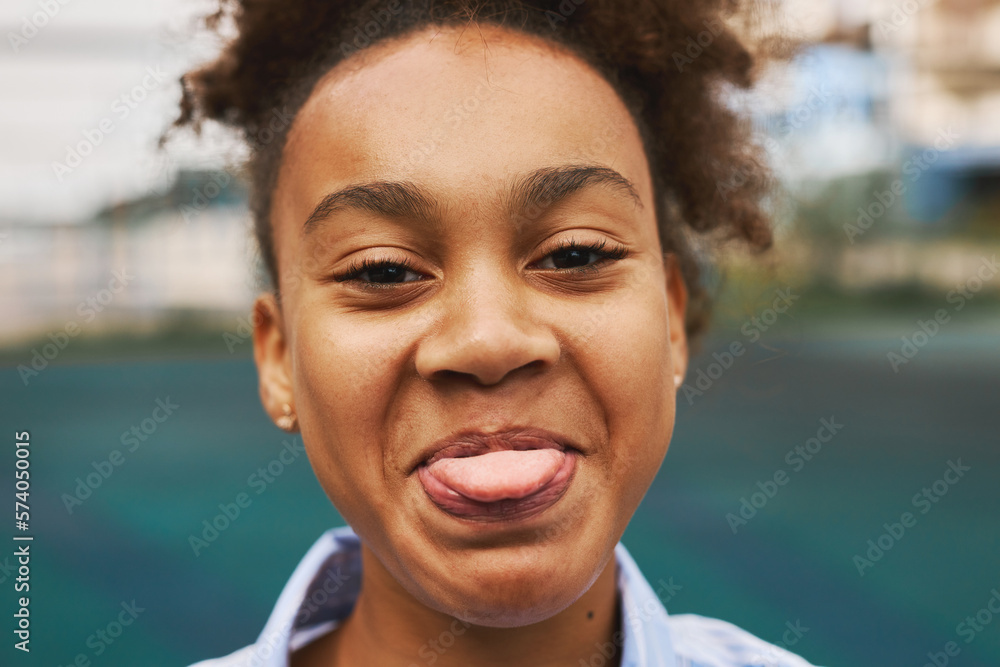 Foto De Face Of Attractive Youthful African American Girl Showing Her Tongue While Standing In