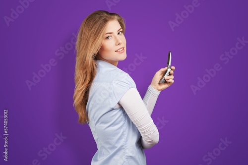Smiling young woman posing with phone