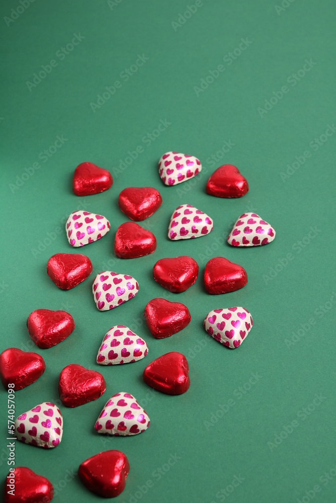 photo chocolate candy in a red wrapper lying on a colored background photo chocolate candy in a red wrapper lying on a colored background