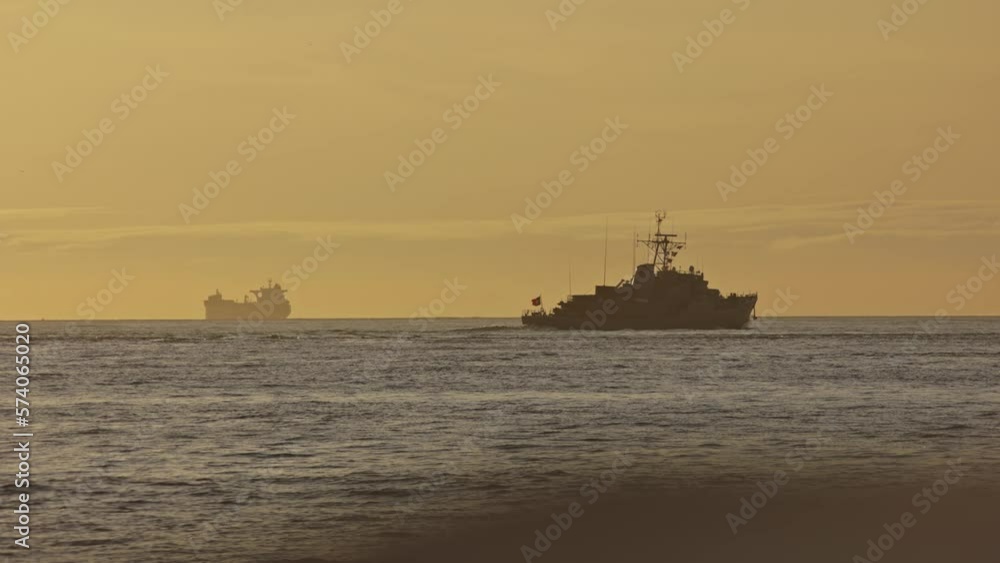 A ship with the flag of Portugal sails the sea at sunset A ship with the flag of Portugal sails the sea at sunset