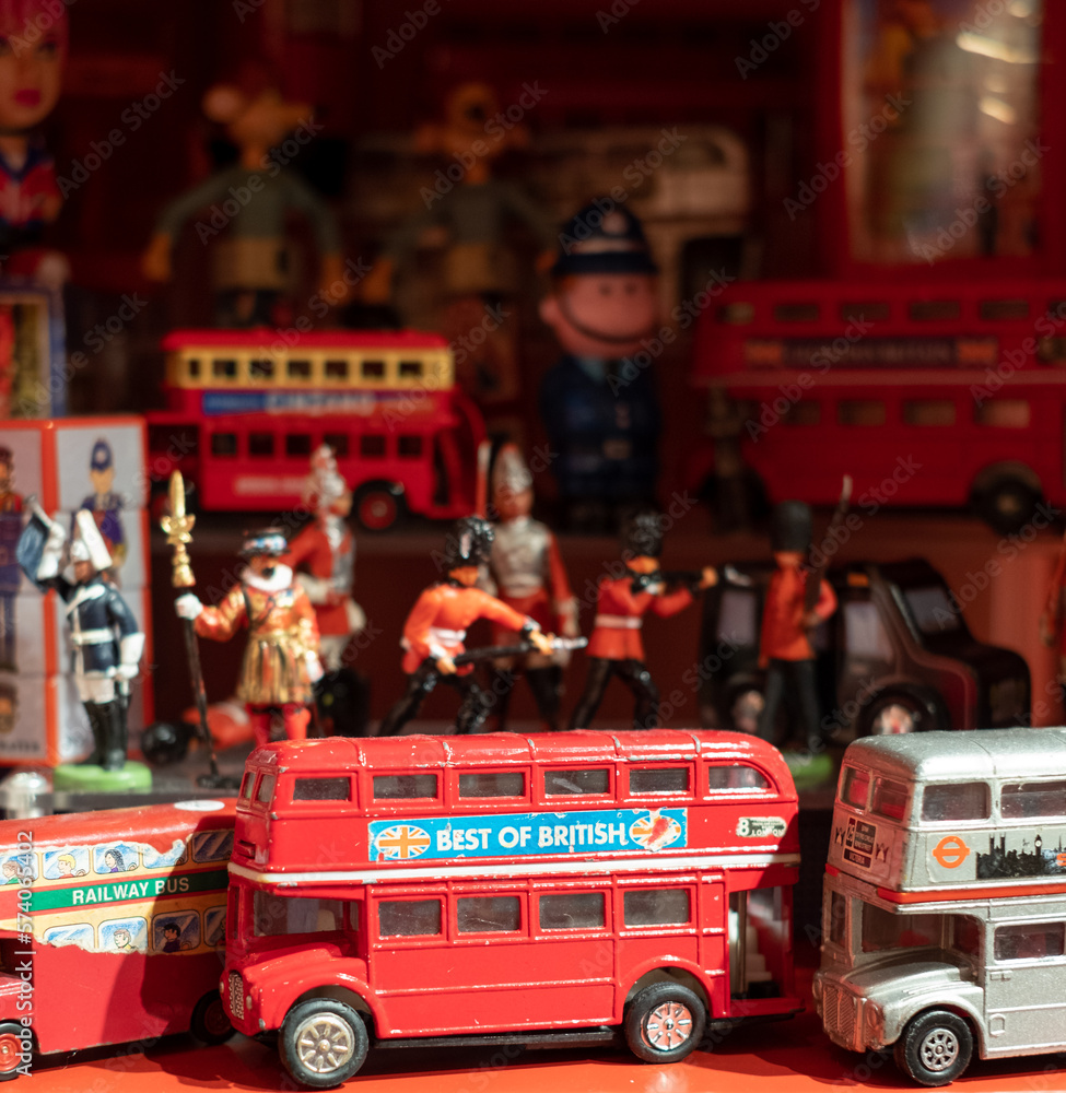 Photo Art Print Model of iconic vintage red double decker London bus with slogan Best of British on the side photographed amongst other toys figures and models on a shelf in