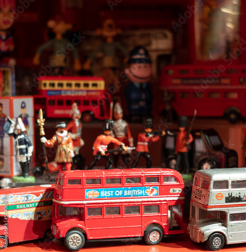 Fototapeta Model of iconic vintage red double decker London bus with slogan 'Best of British' on the side, photographed amongst other toys, figures and models on a shelf in a toy shop in London UK