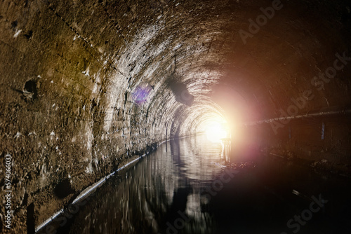 Underground vaulted urban sewer tunnel with dirty sewage