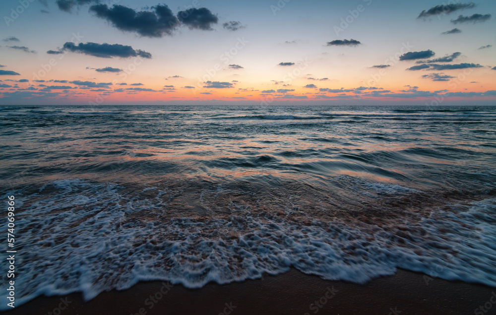 Obraz premium Sunset over the sandy beach of Mediterranean sea in Israel