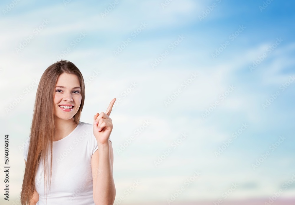 Happy young woman pointing to copy space Happy young woman pointing to copy space