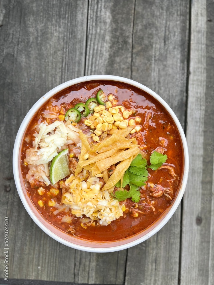 Chicken tortilla soup, topped with tortilla strips, cheese, cilantro, lime, corn, jalapeño. Chicken tortilla soup, topped with tortilla strips, cheese, cilantro, lime, corn, jalapeño.