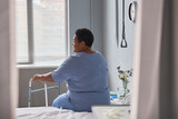 Back view of lonely senior woman in hospital room, minimal