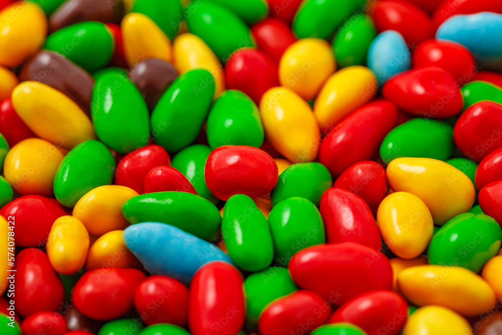 Candy in multi colored glaze in bulk, grains kernels seeds, uniform texture pattern, wallpaper background, selective focus Candy in multi colored glaze in bulk, grains kernels seeds, uniform texture pattern, wallpaper background, selective focus