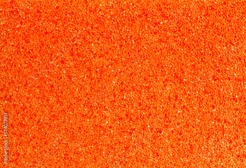 Foam rubber orange sponge, pores close-up background wallpaper, uniform texture pattern