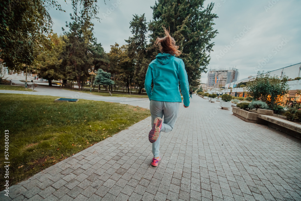 Women in sports clothes running in a modern urban environment. The concept of a sporty and healthy lifestyle Women in sports clothes running in a modern urban environment. The concept of a sporty and healthy lifestyle