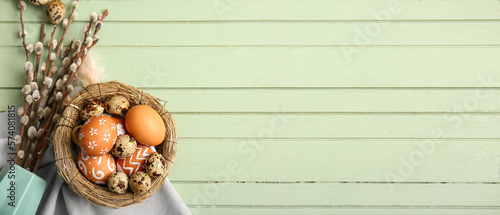 Photos Nest of Easter eggs and pussy willow branches on wooden background with space fo