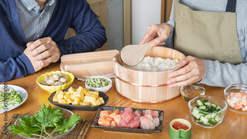 日本の料理｜ちらし寿司の調理をする男女　イメージ