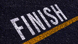 Finish text written and yellow line on the road in middle of the asphalt road, for business planning strategies and challenges, road to success concept, Finish word on street