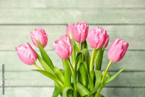 Beautiful tulip flowers on green wooden background