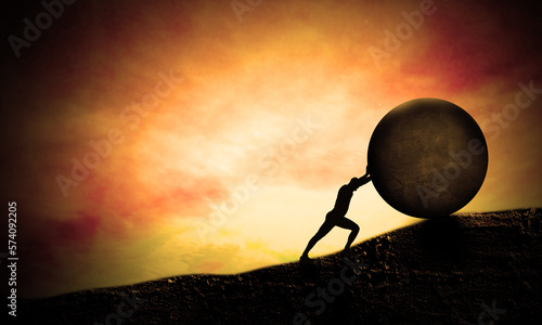 Young Business man Pushing Big stone up to hill. Sunset scene. Concept of Heavy tasks and problems, Difficulty and Hard Work. Sisyphus.  photo