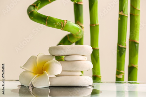 Stack of spa stones  flower and bamboo on light background