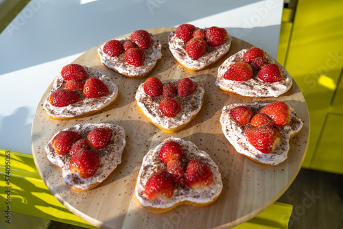 Delicious heart shaped cakes with cream, strawberries and chocolate chips