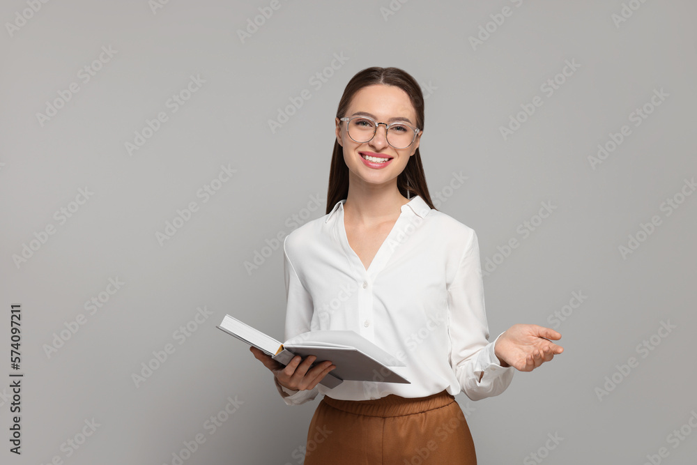 Portrait of beautiful young teacher on grey background Portrait of beautiful young teacher on grey background